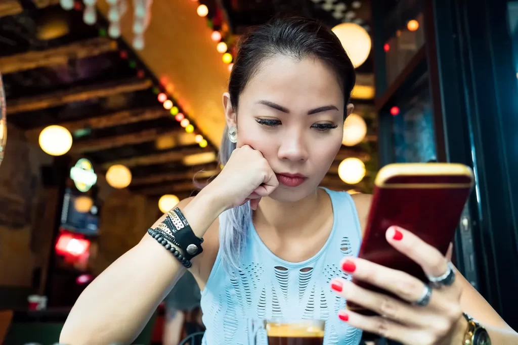a worried woman looking at her smartphone